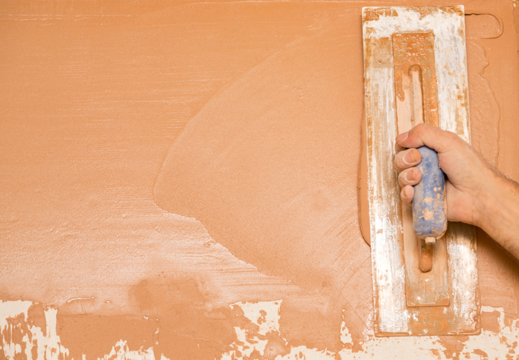 A plasterer is skimming a wall.